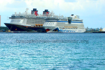 Die Kreuzfahrtschiffe Aidaluna und die Disney Dream nebeneinander im Hafen auf den Bahamas vor Anker, ein guter Größenvergleich.